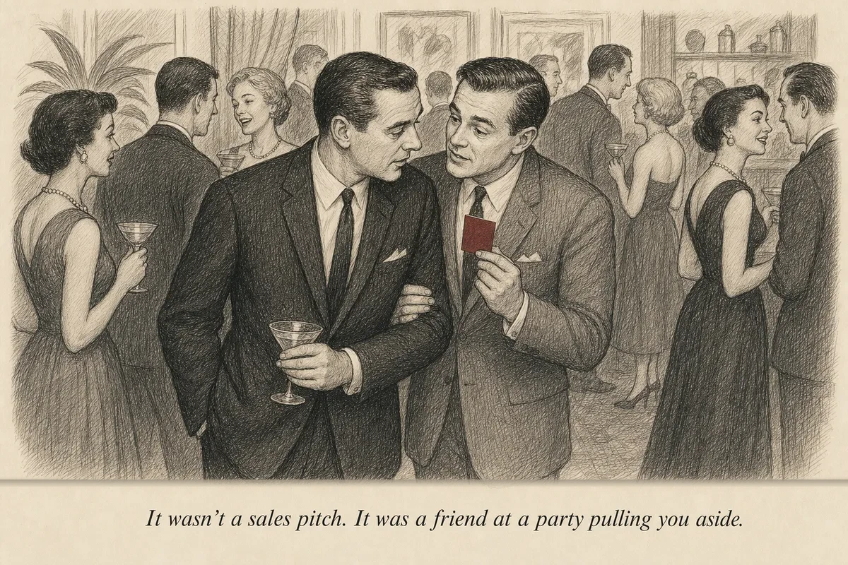 A man at a cocktail party pulling a friend aside to quietly show him something while the rest of the party continues in the background